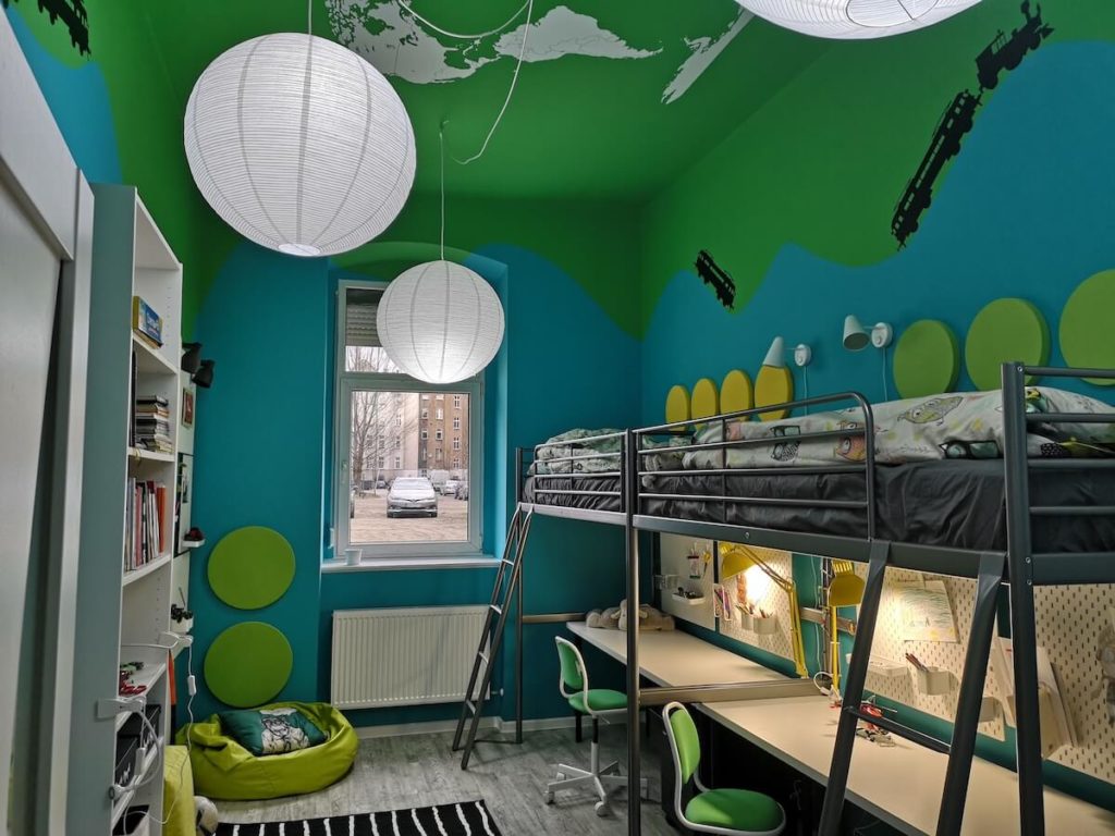 pomalowany pokoj dzieci z naklejkami w pociagi i pietrowymi łożkami